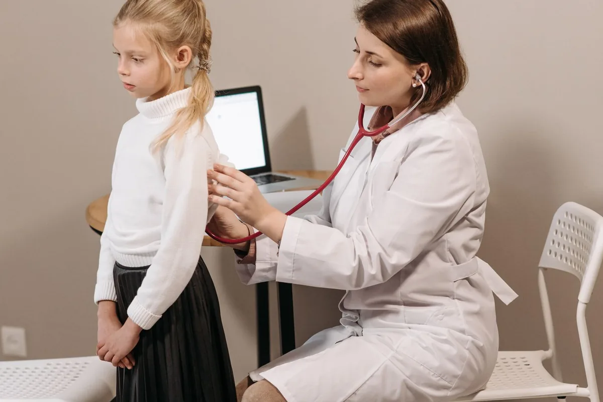 Gyermekorvos vizsgál egy kislányt a rendelőben